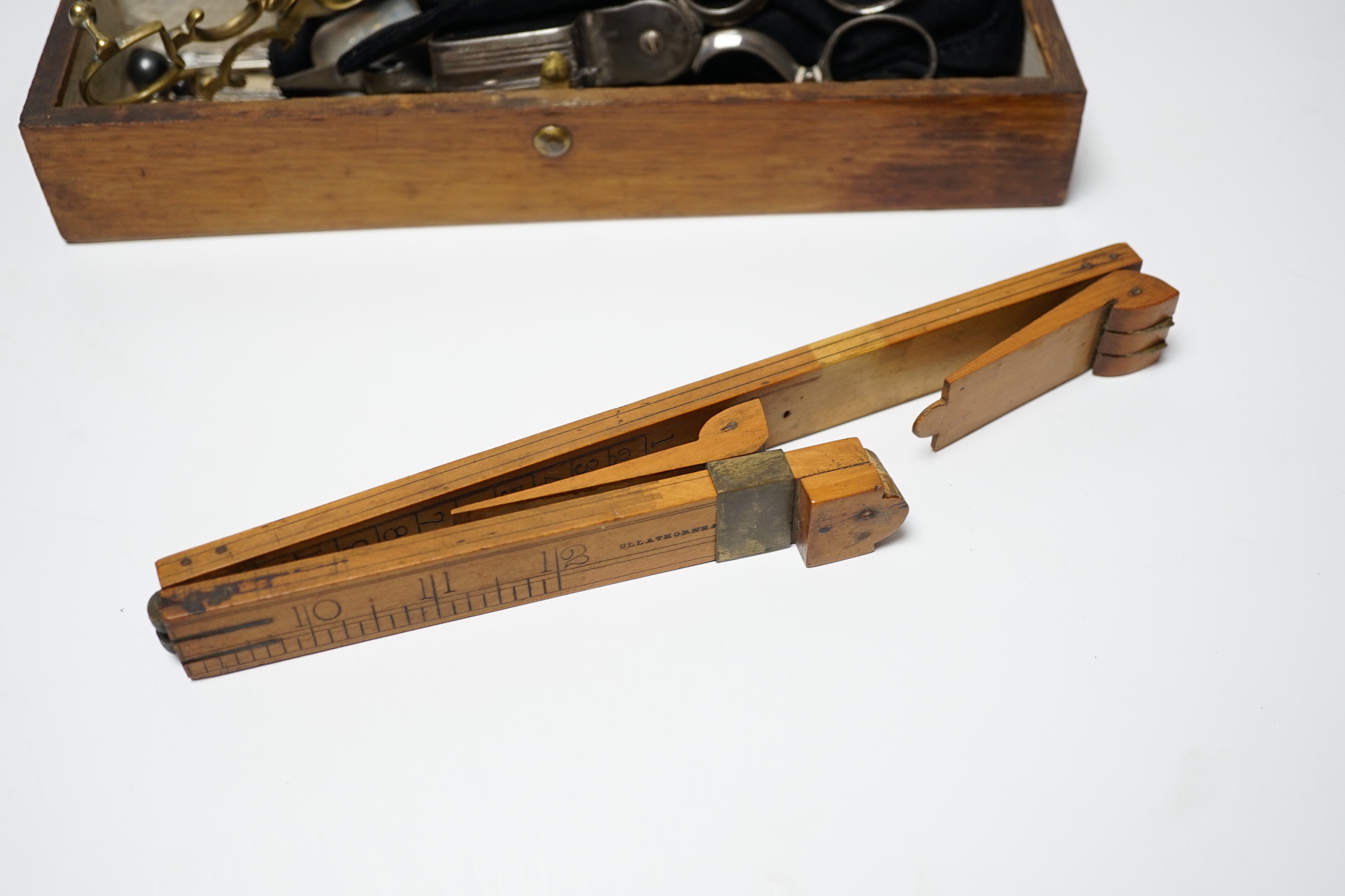 A glove box containing a boxwood foot-measure, two candle snuffers, a silver teaspoon etc